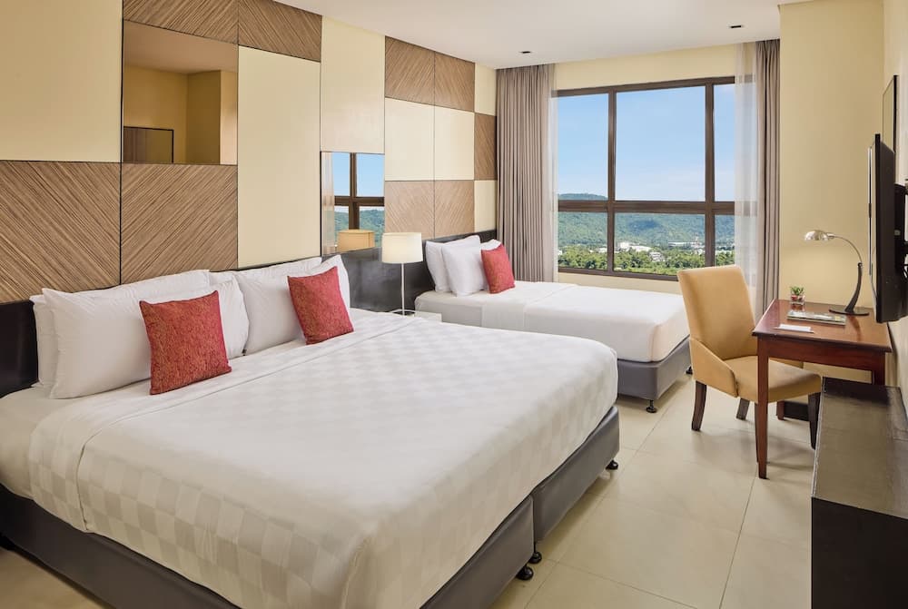 A cozy hotel room with two neatly made beds, a scenic view through large windows, and modern furnishings creates an inviting atmosphere ideal for travelers seeking comfort and relaxation.