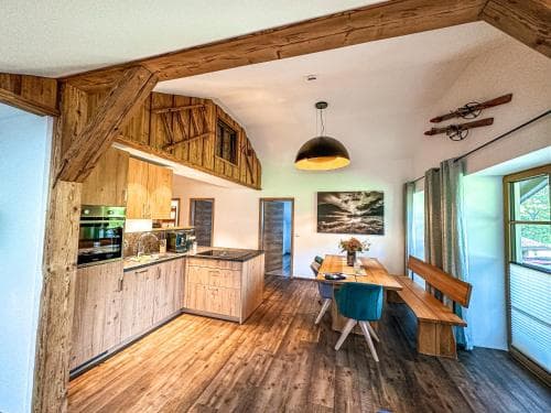 A cozy, rustic cabin interior featuring wooden beams, floors, and furniture, exudes warmth and comfort, ideal for travelers seeking a serene retreat in nature.