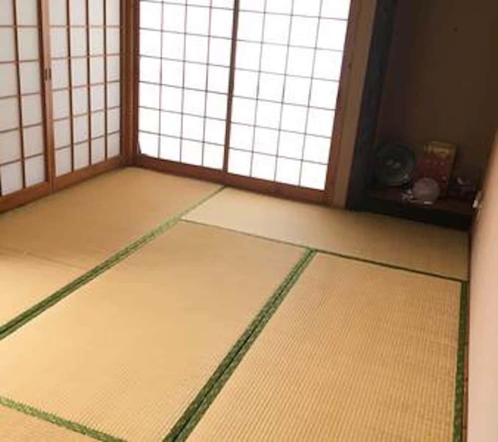 A serene traditional Japanese tatami room with shoji screens and minimal decor offers a peaceful retreat for travelers seeking cultural immersion.