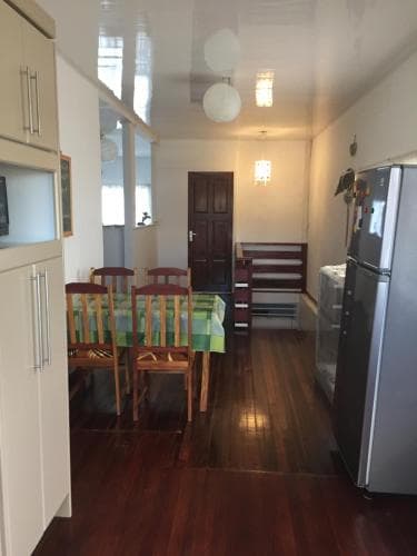 A cozy apartment dining area with wooden floors, a table set for meals under soft lighting, and modern appliances, ideal for travelers seeking a homey stay in an urban setting.