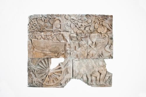 An intricately carved ancient stone panel featuring mythical creatures and wheels, ideal for cultural heritage tourism and museum exhibits.