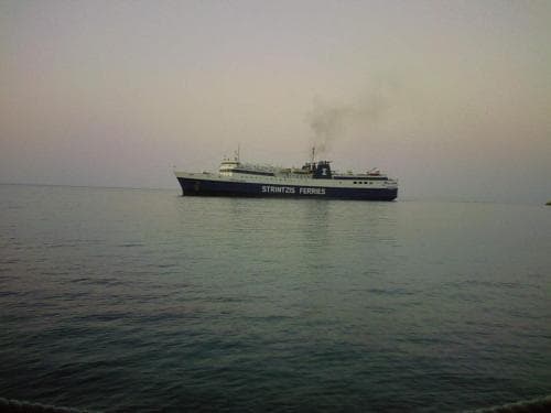 A serene maritime scene features a ferry labeled "STRANZEE FERRIES" cruising on calm waters under a soft twilight sky, ideal for travelers seeking coastal adventures or island hopping experiences.