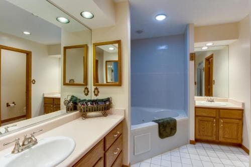 A cozy bathroom with wooden cabinets, a tiled floor, and a blue-tiled shower area creates a serene atmosphere, ideal for travelers seeking relaxation and comfort during their stay.