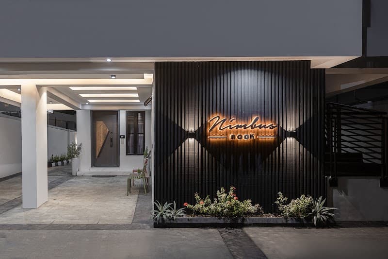 The modern entrance of Nimbus Nook Apartment in Ikeja GRA, Lagos, features sleek lighting, a stylish signboard, and lush greenery, creating an inviting atmosphere ideal for travelers seeking upscale short-term accommodations.