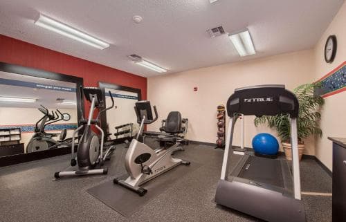 A well-lit indoor fitness center featuring treadmills, ellipticals, and exercise balls creates an inviting atmosphere for travelers seeking a workout during their stay.
