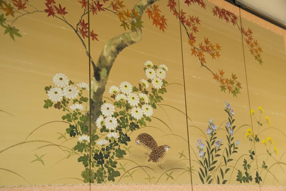 A serene Japanese-style painted screen features vibrant autumn leaves, delicate white flowers, and a quail, ideal for cultural exploration and interior design inspiration.