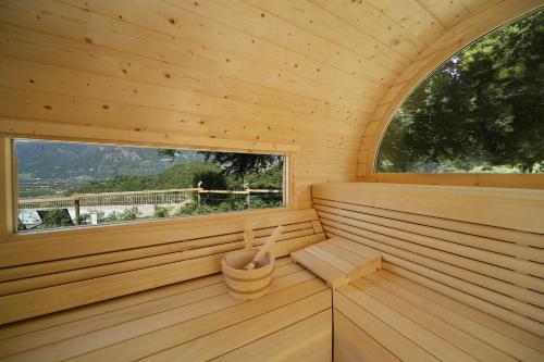A serene wooden sauna offers a tranquil retreat with scenic mountain views through its window, perfect for relaxation and wellness travel.