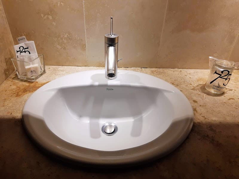 A clean hotel bathroom sink with modern fixtures and branded amenities at the 725 Continental Hotel in Buenos Aires, Argentina, offers travelers a comfortable and stylish accommodation experience.
