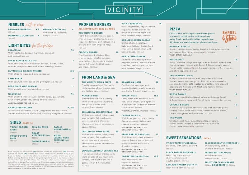 A vibrant menu from the Vicinity restaurant at The Tower Hotel in London showcases an array of appetizing dishes like burgers, pizzas, and seafood, perfect for travelers seeking a hearty meal with a view near iconic landmarks.