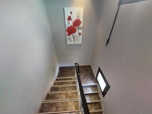 A cozy indoor staircase adorned with a vibrant floral artwork creates an inviting atmosphere, perfect for travelers seeking a charming and well-decorated accommodation experience.