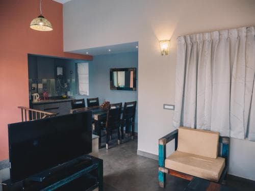A cozy apartment interior features a vibrant color scheme with a dining area, kitchenette, and living space, creating an inviting atmosphere ideal for travelers seeking comfort and style in their accommodations.