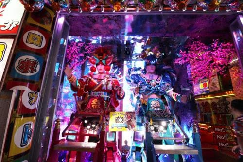 A vibrant arcade scene featuring colorful, ornate game machines adorned with cherry blossoms, perfect for travelers seeking an immersive cultural gaming experience in a lively entertainment district.