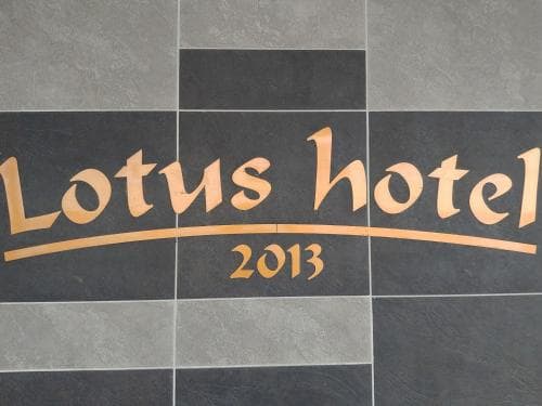 A sleek tiled wall featuring the "Lotus Hotel 2013" logo in gold lettering sets a modern and elegant tone, ideal for travelers seeking a stylish accommodation experience.