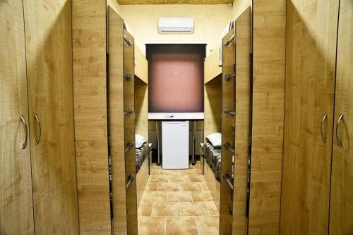 A cozy locker room with wooden lockers and tiled floors creates a warm, functional space ideal for travelers seeking a private changing area or storage in a gym or spa setting.
