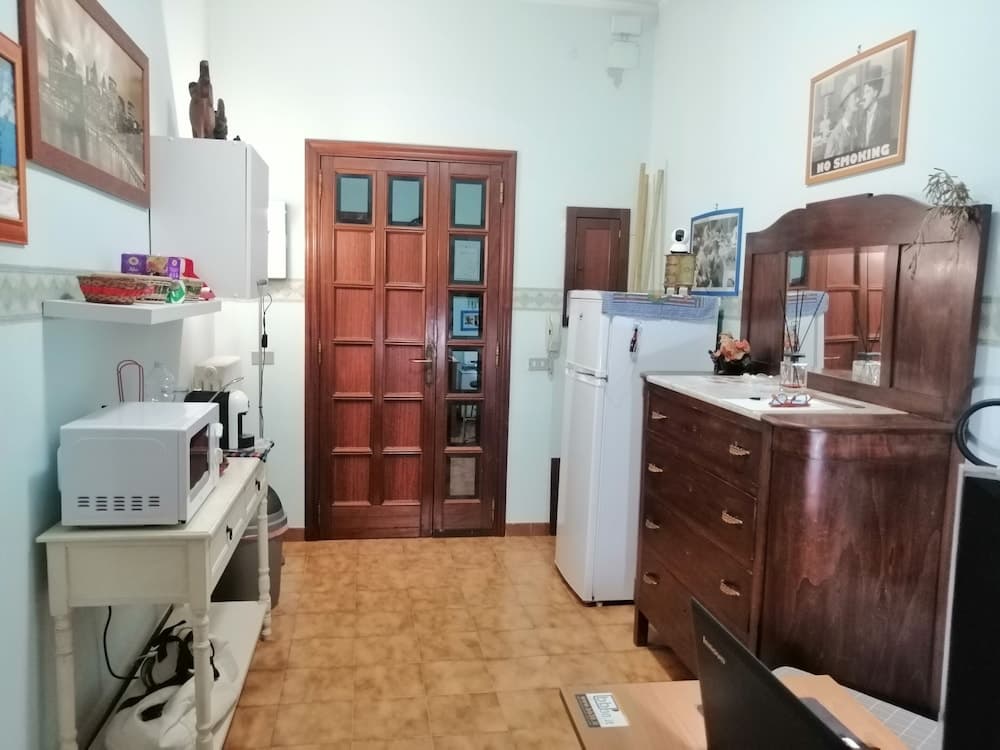 A cozy, lived-in room with a wooden dresser, white appliances, and framed pictures creates a warm, homey atmosphere ideal for travelers seeking a comfortable stay in a private accommodation.