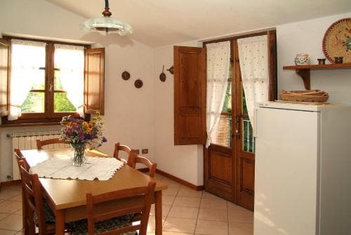 A cozy, sunlit dining area with wooden furniture, floral arrangements, and rustic decor invites travelers to relax in a charming countryside retreat.