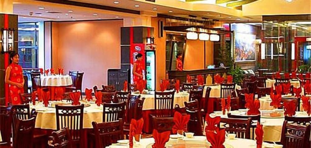 A vibrant indoor restaurant with red accents, neatly arranged tables, and staff in traditional attire creates a welcoming atmosphere ideal for travelers seeking an authentic dining experience.