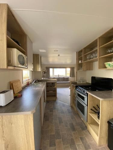 A cozy, well-lit kitchen in a vacation rental features wooden cabinets, modern appliances, and a spacious layout ideal for family gatherings and culinary adventures.