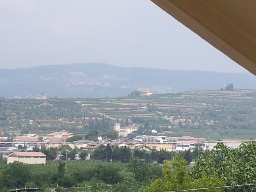 A serene view of terraced hills and distant mountains frames a quaint village, ideal for travelers seeking peaceful rural retreats and scenic vistas.