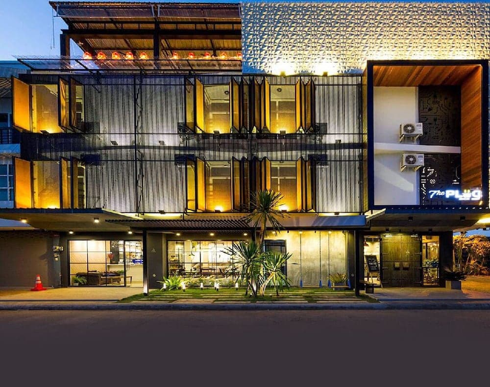 A modern, illuminated hotel facade with geometric patterns and warm lighting creates an inviting atmosphere at dusk, ideal for travelers seeking stylish accommodations.