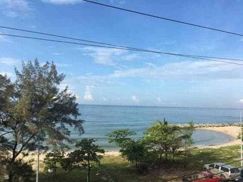 A serene coastal view featuring lush greenery, sandy beaches, and calm blue waters under a clear sky, ideal for relaxing beachside getaways and nature photography.