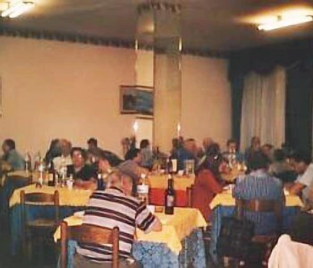 A cozy indoor dining hall filled with guests enjoying meals at long tables adorned with yellow tablecloths, ideal for group gatherings or family reunions.