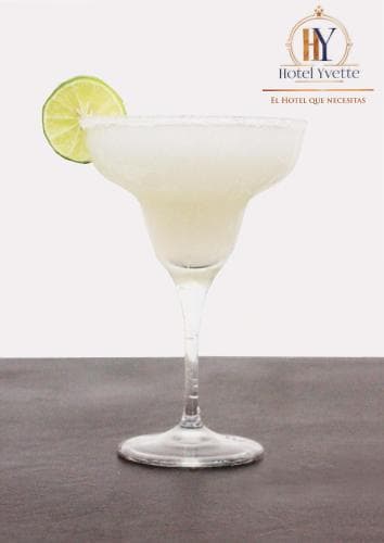 A refreshing margarita garnished with a lime slice sits elegantly on a dark surface, perfect for a relaxing hotel stay or a tropical getaway, enhancing the mood of leisure and indulgence.