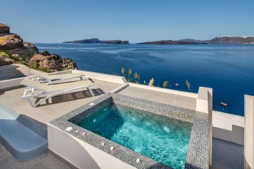 A serene coastal villa features a sparkling pool overlooking the vast blue sea, ideal for luxury relaxation and scenic photography.