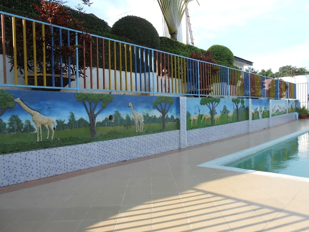 A vibrant poolside area features colorful railings and wildlife murals, creating a cheerful and artistic atmosphere ideal for family-friendly vacations.