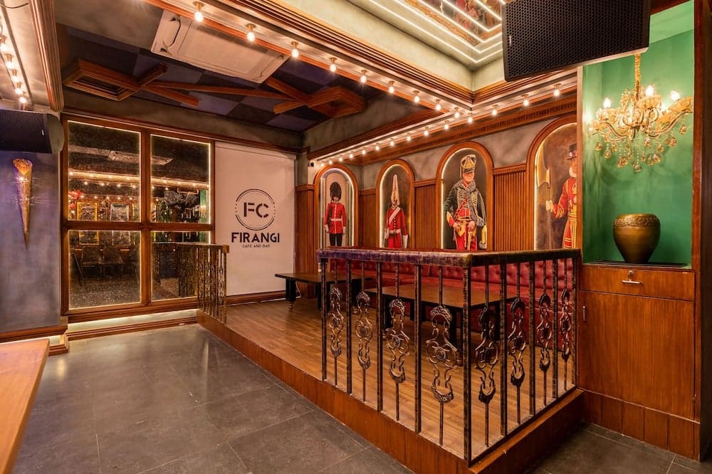An opulent indoor café and bar features vibrant historical portraits, elegant chandeliers, and ornate railings, creating an inviting atmosphere perfect for travelers seeking a unique dining experience.