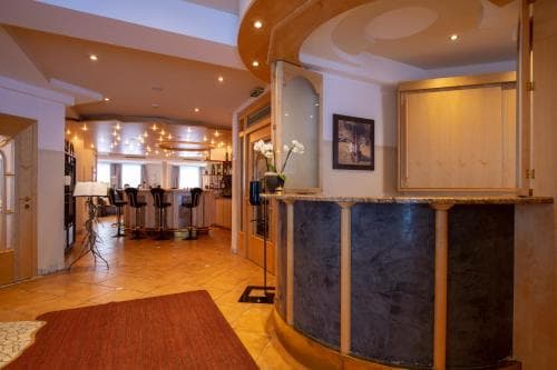 A cozy hotel lobby with warm lighting, wooden accents, and a reception desk sets a welcoming tone for travelers seeking comfort and relaxation.