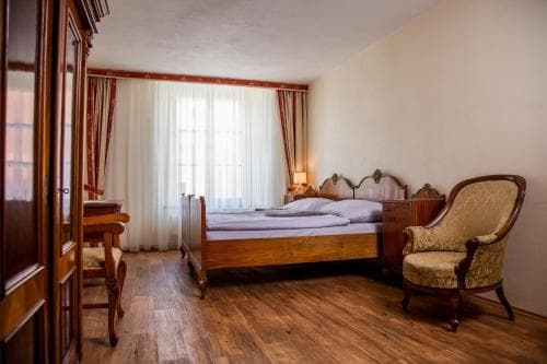 A cozy hotel room with wooden floors, vintage furniture, and soft lighting creates a warm and inviting atmosphere, perfect for travelers seeking comfort and charm during their stay.