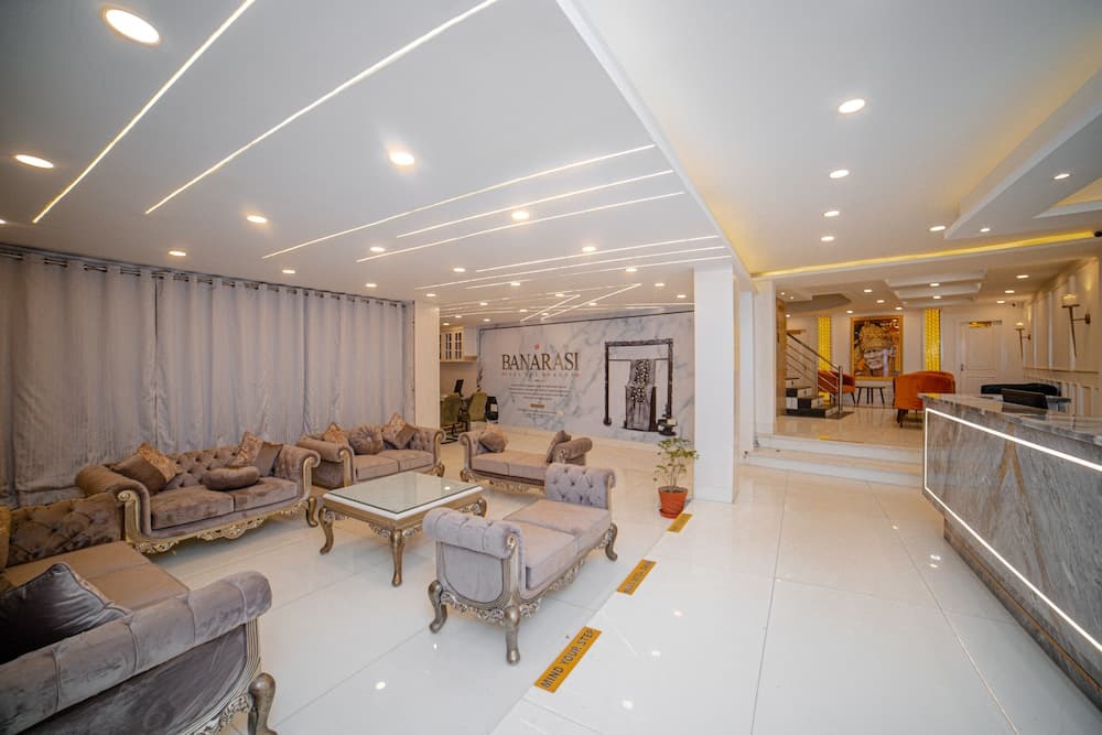 A luxurious hotel lobby features elegant sofas, a marble reception desk, and modern lighting, creating a welcoming atmosphere ideal for travelers seeking comfort and style.