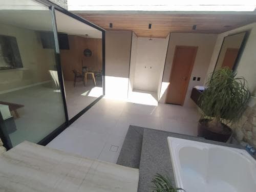 A modern indoor-outdoor living space features large glass doors opening to a cozy interior with wooden accents, creating an inviting atmosphere ideal for vacation rentals or home tours.