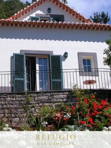 A charming white villa with terracotta roof tiles and lush gardens exudes tranquility, perfect for a serene getaway in a picturesque countryside setting.