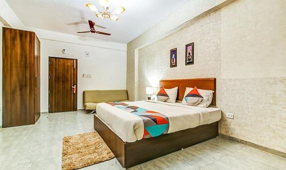 A cozy hotel room features a neatly made bed with colorful bedding, wooden furnishings, and soft lighting, creating a welcoming atmosphere ideal for travelers seeking comfort and relaxation.