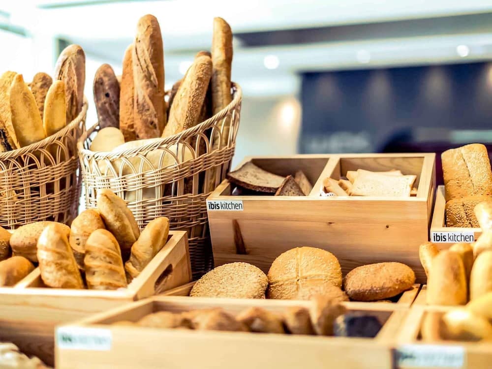 A cozy bakery display featuring an assortment of fresh breads in wooden crates and wicker baskets, inviting travelers to indulge in artisanal delights during their culinary exploration.