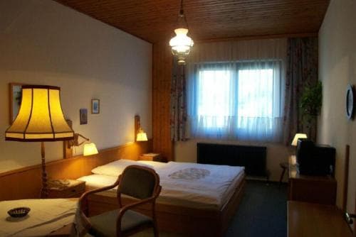 A cozy hotel room with warm lighting, wooden accents, and a neatly made bed by the window, ideal for travelers seeking comfort and relaxation.