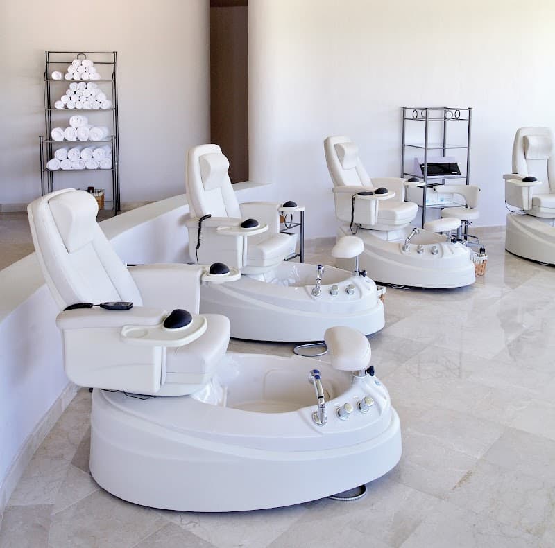 A serene spa area at the Barceló Maya Tropical resort features modern pedicure chairs and neatly stacked towels, ideal for travelers seeking relaxation and pampering in Playa del Carmen, Mexico.