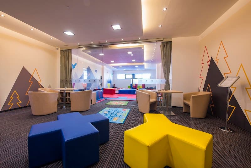 A vibrant children's play area at Hotel Panorama Resort in Štrbské Pleso, Slovakia, features colorful star-shaped seating, playful wall art, and a cozy atmosphere ideal for family-friendly vacations.