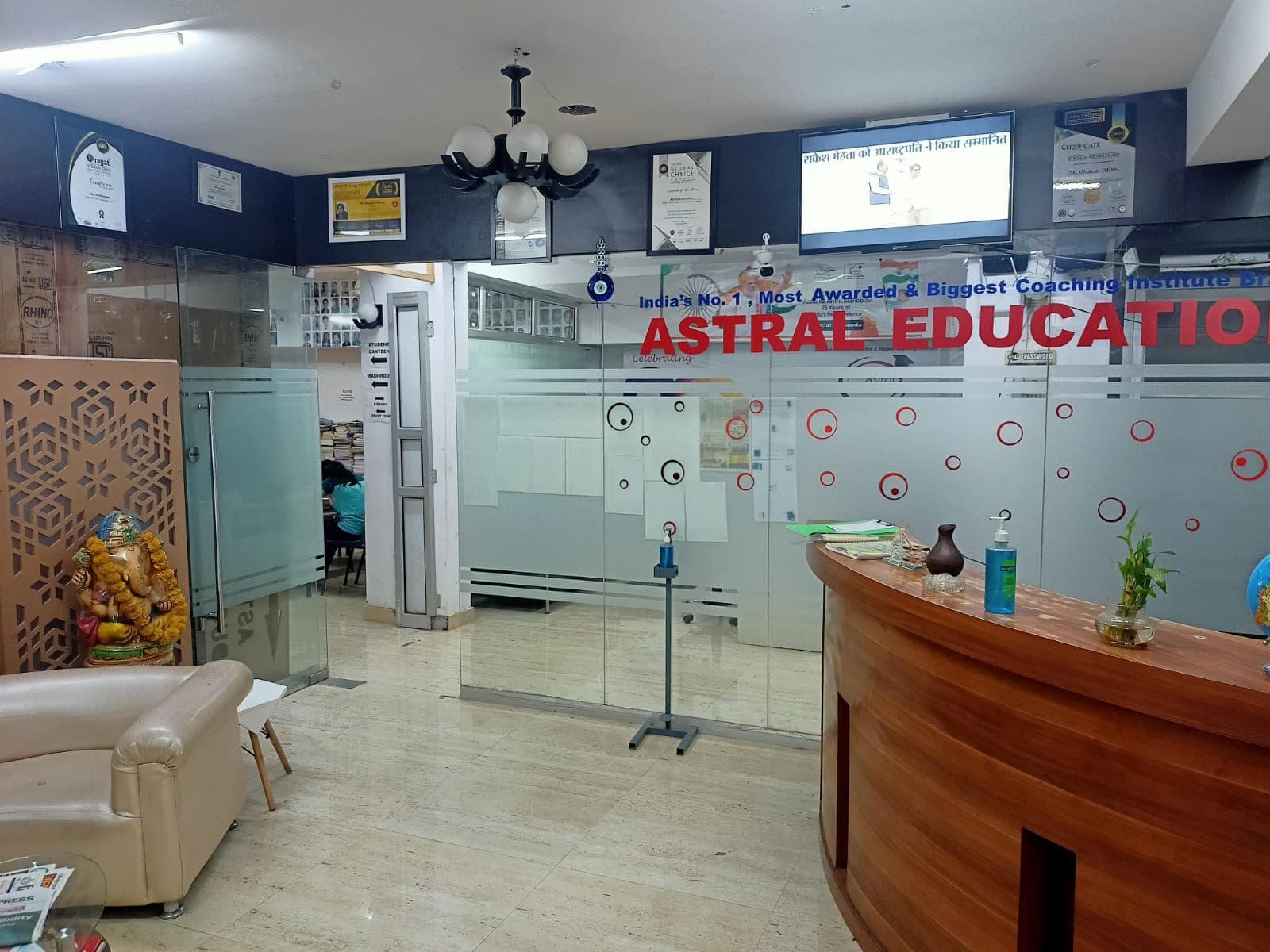 A professional educational office space featuring a reception desk, glass partitions, certificates on display, and a Ganesh statue, ideal for travelers seeking academic coaching services in Gurugram, India.