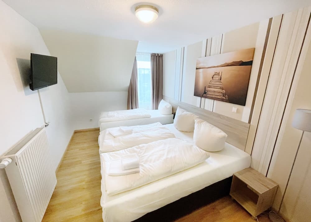 A cozy hotel room with neatly arranged twin beds, soft lighting, and modern decor offers a comfortable stay for travelers seeking relaxation and convenience.