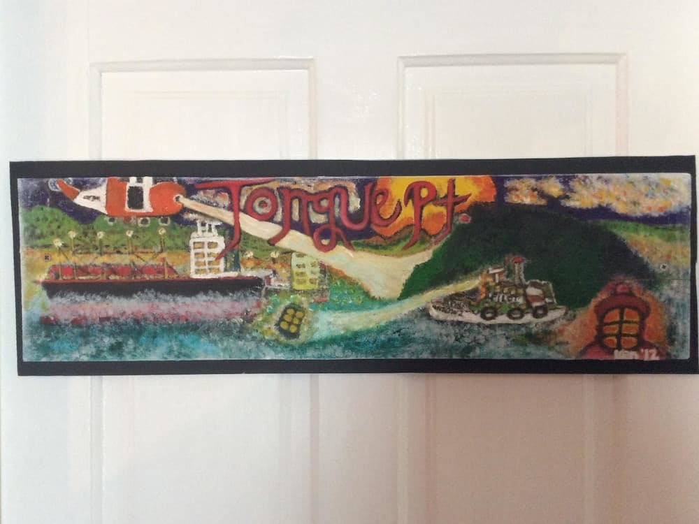 A vibrant mural depicting a coastal town with boats, hills, and the words "Tongue Pt" creates a whimsical and artistic atmosphere, ideal for travelers seeking unique cultural landmarks and local art scenes.