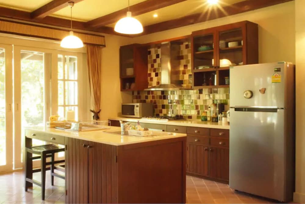 A cozy kitchen with warm wooden tones, colorful mosaic tiles, and natural light streaming through glass doors offers an inviting space for travelers seeking a homey retreat.