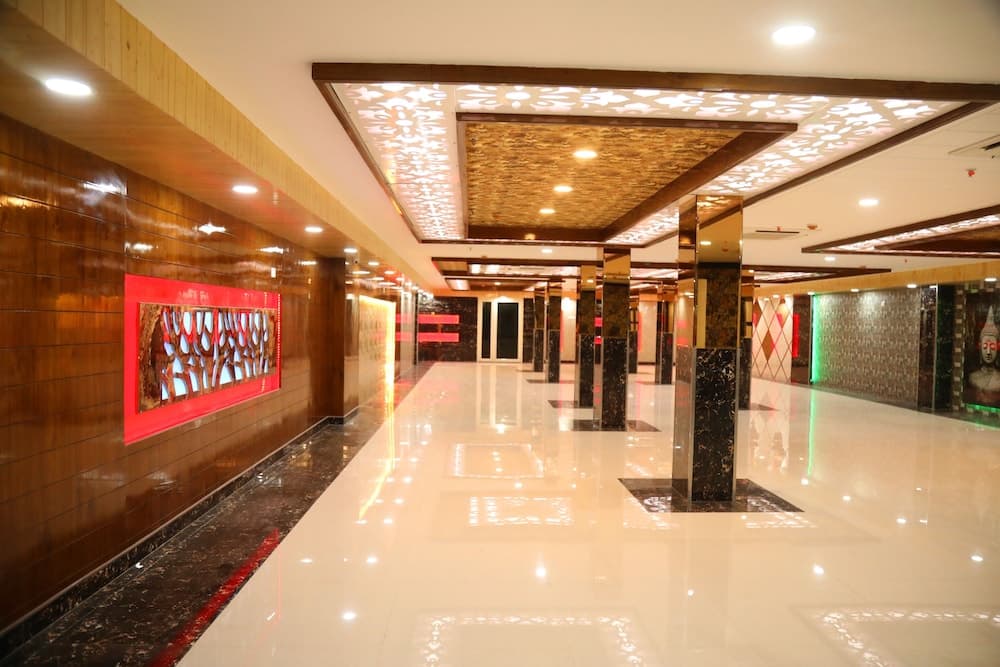 A luxurious hotel corridor features polished marble floors, ornate ceiling designs, and vibrant wall art, creating an elegant atmosphere ideal for travelers seeking upscale accommodations.