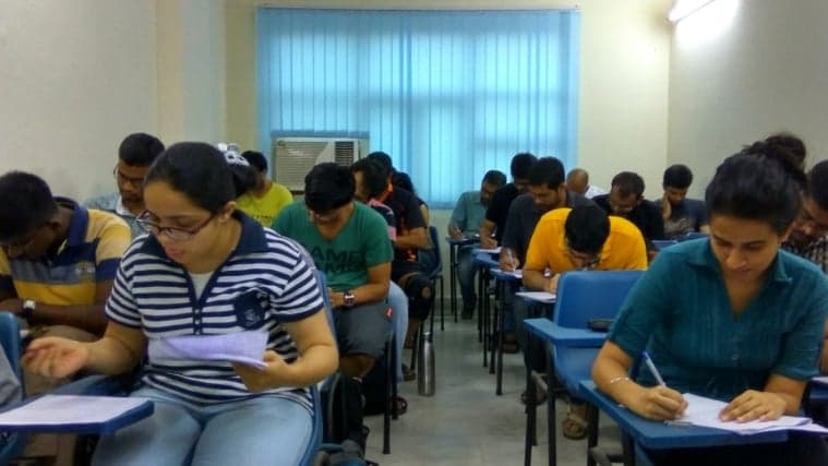 Students diligently take notes in a classroom setting at an educational center in New Delhi, India, ideal for travelers seeking academic or professional development opportunities.