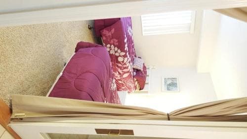 A cozy bedroom with a floral-patterned bedspread and soft lighting creates a warm and inviting atmosphere, ideal for travelers seeking a comfortable and private retreat.