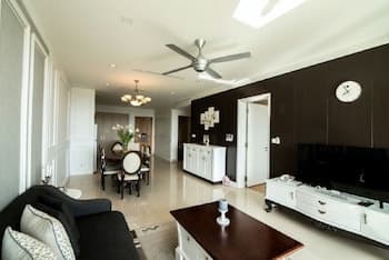 A modern, spacious living room with sleek furniture, a large flat-screen TV, and an open layout exudes comfort and elegance, ideal for travelers seeking a luxurious apartment stay.