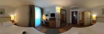 A cozy hotel room with warm lighting, wooden furnishings, and a neatly made bed creates an inviting atmosphere ideal for travelers seeking comfort and relaxation.