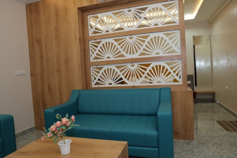 A cozy hotel lounge at Hotel Lord Krishna in Dwarka, Gujarat, features teal sofas, a wooden table with flowers, and decorative wall panels, creating a welcoming atmosphere for travelers seeking comfort and relaxation.